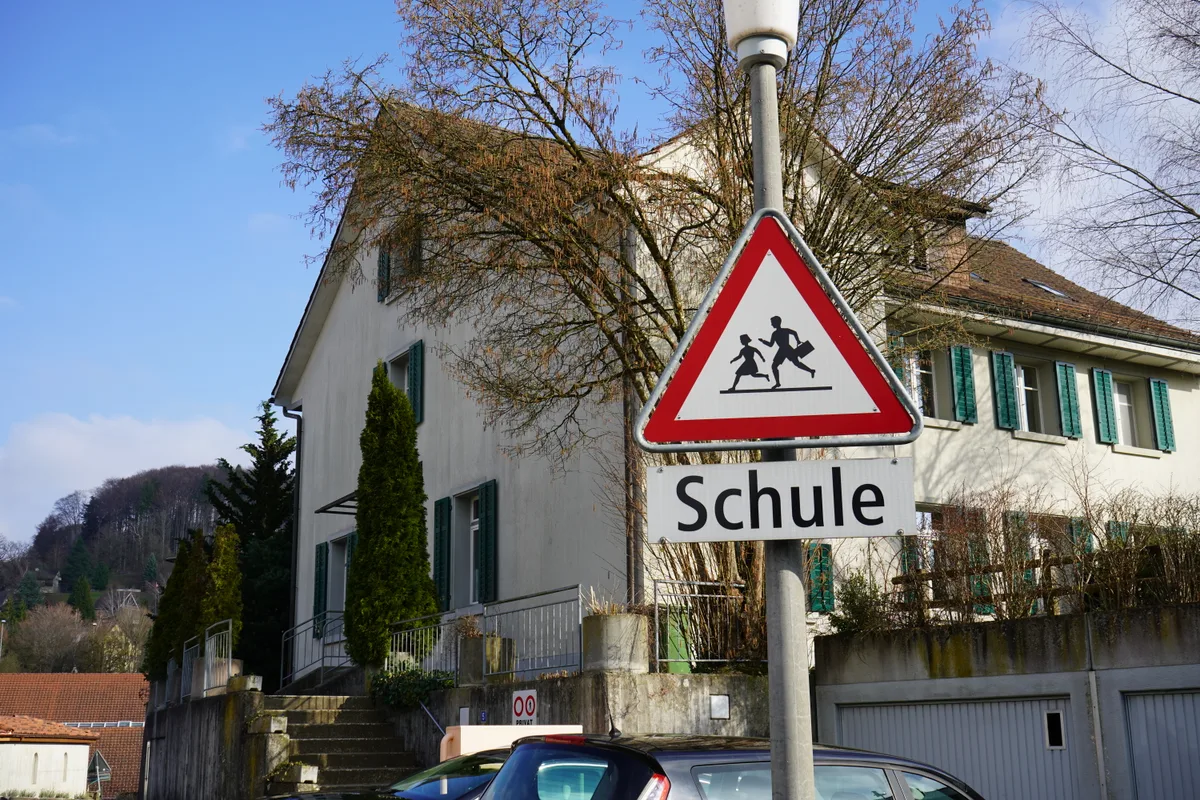 Altes Haus an der Burggasse und Schultafel davor.